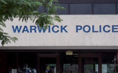 Sargento policía Warwick enfrenta cargos por supuestamente golpear en auto patrulla a detenido esposado.