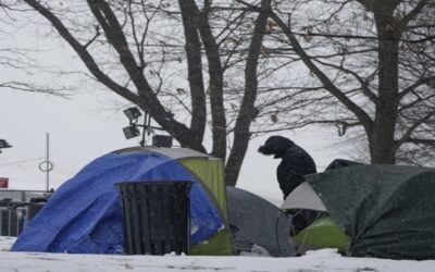 Ante escasez de camas y bajas temperaturas, migrantes colocan campamento frente a albergue de NY